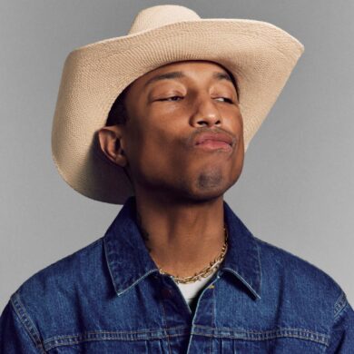 pharrell williams wearing a cowboy hat, denim jacket and yellow gold tiffany and co necklace while pouting